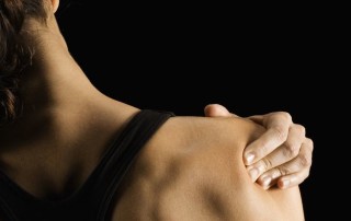 Woman rubbing shoulder, rear view